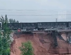 山西洪灾。山西祁县一大桥被冲垮，火车连同铁轨悬空。（视频截图）