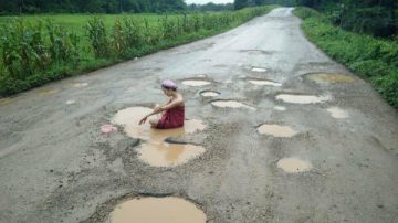 嘲讽公路年久失修 泰女马路坑洞洗浴