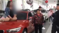 车顶维权 江苏女4S店坐塌宝马引擎盖 商家报警