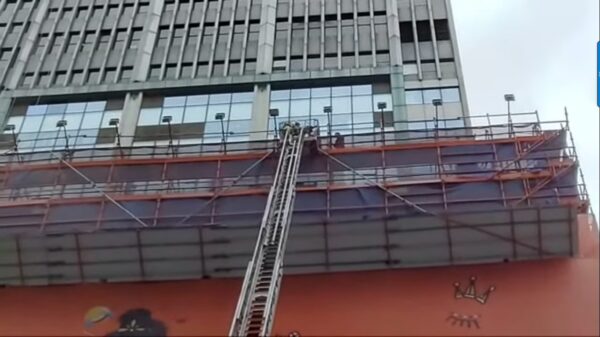 2021年12月15日中午，香港铜锣湾世界贸易中心发生火灾，消防人员从天台上救助被困人员。（大纪元视频截图）