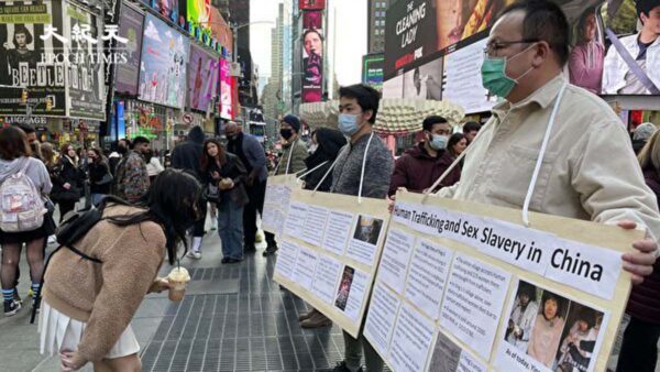 中国留学生时代广场举牌 吁关注徐州八孩母案