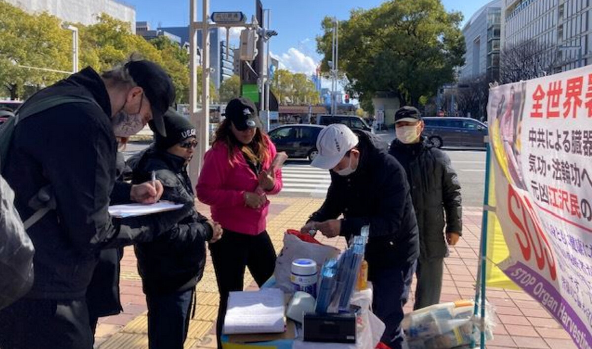 過往市民駐足了解真相,有的簽名聲援訴江。(明慧網)