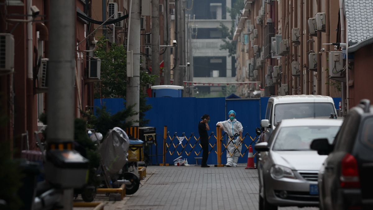 2022年6月17日,北京一名身穿防護服的警衛站立在封閉小區鐵柵欄處。(Lintao Zhang/Getty Images)