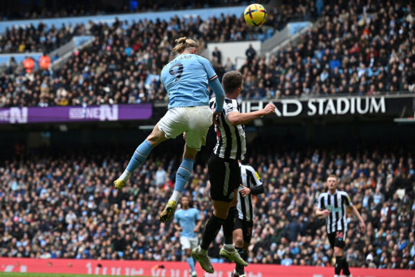 TOPSHOT - Manchester City's Norwegian striker Erling Haaland (L) attempts to head the ball during the English Premier League football match between Manchester City and Newcastle United at the Etihad Stadium in Manchester, north west England, on March 4, 2023. (Photo by Paul ELLIS / AFP) / RESTRICTED TO EDITORIAL USE. No use with unauthorized audio, video, data, fixture lists, club/league logos or 'live' services. Online in-match use limited to 120 images. An additional 40 images may be used in extra time. No video emulation. Social media in-match use limited to 120 images. An additional 40 images may be used in extra time. No use in betting publications, games or single club/league/player publications. / (Photo by PAUL ELLIS/AFP via Getty Images)