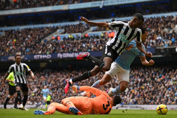 TOPSHOT - Manchester City's Brazilian goalkeeper Ederson saves at the feet of Newcastle United's Swedish striker Alexander Isak during the English Premier League football match between Manchester City and Newcastle United at the Etihad Stadium in Manchester, north west England, on March 4, 2023. (Photo by Paul ELLIS / AFP) / RESTRICTED TO EDITORIAL USE. No use with unauthorized audio, video, data, fixture lists, club/league logos or 'live' services. Online in-match use limited to 120 images. An additional 40 images may be used in extra time. No video emulation. Social media in-match use limited to 120 images. An additional 40 images may be used in extra time. No use in betting publications, games or single club/league/player publications. / (Photo by PAUL ELLIS/AFP via Getty Images)