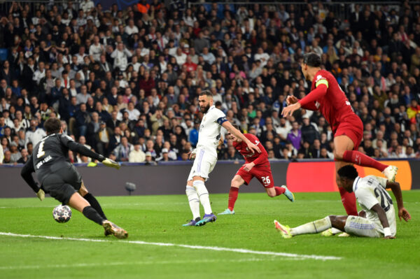 MADRID, SPAIN - MARCH 15: Karim Benzema of Real Madrid scores the team's first goal as Alisson Becker and Virgil van Dijk of Liverpool look on during the UEFA Champions League round of 16 leg two match between Real Madrid and Liverpool FC at Estadio Santiago Bernabeu on March 15, 2023 in Madrid, Spain. (Photo by Denis Doyle/Getty Images)