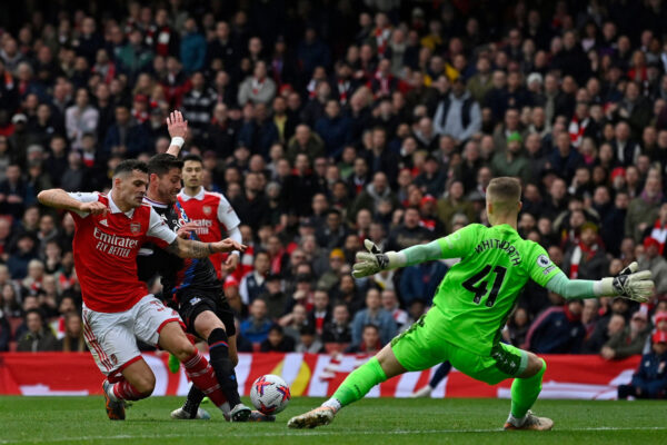 Arsenal's Swiss midfielder Granit Xhaka (L) shoots to score their third goal past Crystal Palace's English goalkeeper Joseph Whitworth (R) during the English Premier League football match between Arsenal and Crystal Palace at the Emirates Stadium in London on March 19, 2023. (Photo by JUSTIN TALLIS / AFP) / RESTRICTED TO EDITORIAL USE. No use with unauthorized audio, video, data, fixture lists, club/league logos or 'live' services. Online in-match use limited to 120 images. An additional 40 images may be used in extra time. No video emulation. Social media in-match use limited to 120 images. An additional 40 images may be used in extra time. No use in betting publications, games or single club/league/player publications. / (Photo by JUSTIN TALLIS/AFP via Getty Images)