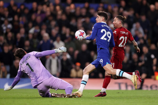 LONDON, ENGLAND - APRIL 04: Kai Havertz of Chelsea handballs while under pressure from Alisson Becker of Liverpool and Kostas Tsimikas of Liverpool during the Premier League match between Chelsea FC and Liverpool FC at Stamford Bridge on April 04, 2023 in London, England. (Photo by Ryan Pierse/Getty Images)