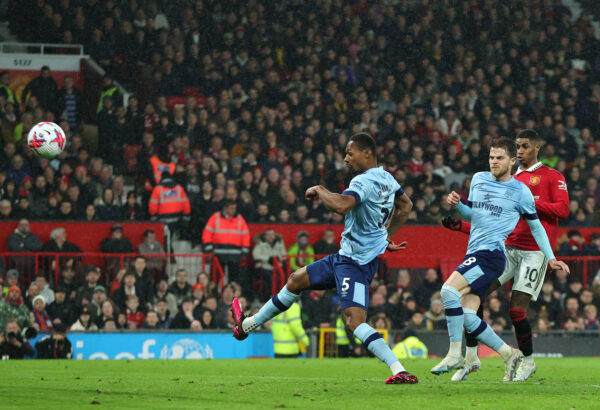 MANCHESTER, ENGLAND - APRIL 05: Marcus Rashford of Manchester United scores the team's first goal whilst under pressure from Mathias Jensen and Ethan Pinnock of Brentford during the Premier League match between Manchester United and Brentford FC at Old Trafford on April 05, 2023 in Manchester, England. 