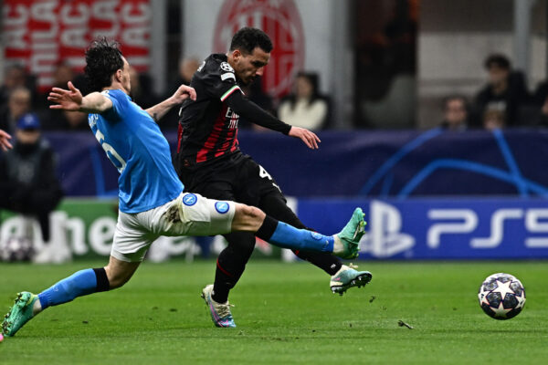 AC Milan's Algerian defender Ismael Bennacer shoots to open the scoring despite Napoli's Portuguese defender Mario Rui (L) during the UEFA Champions League quarter-finals first leg football match between AC Milan and SSC Napoli on April 12, 2023 at the San Siro stadium in Milan. (Photo by GABRIEL BOUYS / AFP) 