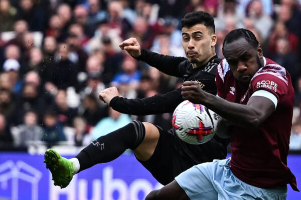 Arsenal's Brazilian midfielder Gabriel Martinelli (L) kicks the ball that will touch the hand of West Ham United's English midfielder Michail Antonio (R) giving Arsenal team a penalty kick during the English Premier League football match between West Ham United and Arsenal at the London Stadium, in London on April 16, 2023. (Photo by Ben Stansall / AFP) / RESTRICTED TO EDITORIAL USE. No use with unauthorized audio, video, data, fixture lists, club/league logos or 'live' services. Online in-match use limited to 120 images. An additional 40 images may be used in extra time. No video emulation. Social media in-match use limited to 120 images. An additional 40 images may be used in extra time. No use in betting publications, games or single club/league/player publications. / 