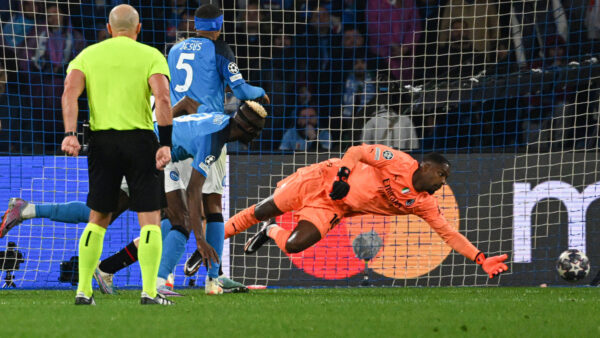Napoli's Nigerian forward Victor Osimhen (2ndL) scores a last minute header past AC Milan's French goalkeeper Mike Maignan during the UEFA Champions League quarter-finals second leg football match between SSC Napoli and AC Milan on April 18, 2023 at the Diego-Maradona stadium in Naples. (Photo by Andreas SOLARO / AFP) 