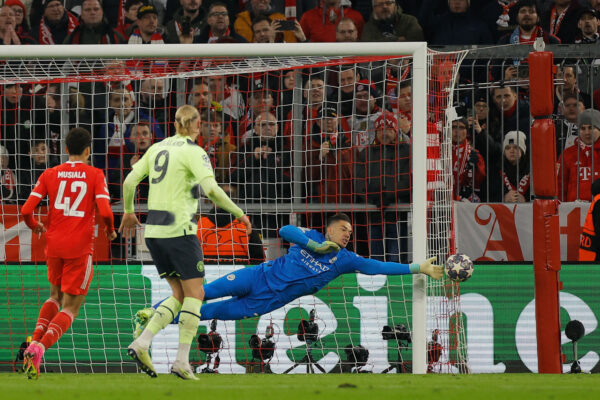 Manchester City's Brazilian goalkeeper Ederson (R) saves a free kick during the UEFA Champions League quarter final, secong leg football match between Bayern Munich and Manchester City at the Allianz Arena in Munich, southern Germany on April 11, 2023. (Photo by Odd ANDERSEN / AFP) 