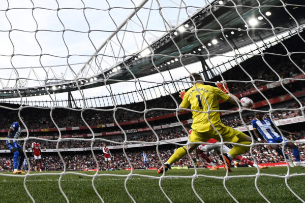 Brighton's Ecuadorian defender Pervis Estupinan (rear R) shoots and scores his team third goal during the English Premier League football match between Arsenal and Brighton and Hove Albion at the Emirates Stadium in London on May 14, 2023. (Photo by Glyn KIRK / AFP) / RESTRICTED TO EDITORIAL USE. No use with unauthorized audio, video, data, fixture lists, club/league logos or 'live' services. Online in-match use limited to 120 images. An additional 40 images may be used in extra time. No video emulation. Social media in-match use limited to 120 images. An additional 40 images may be used in extra time. No use in betting publications, games or single club/league/player publications. / 