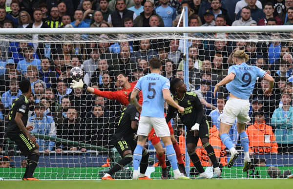 TOPSHOT - Real Madrid's Belgian goalkeeper Thibaut Courtois saves a header from Manchester City's Norwegian striker Erling Haaland (R) during the UEFA Champions League second leg semi-final football match between Manchester City and Real Madrid at the Etihad Stadium in Manchester, north west England, on May 17, 2023. (Photo by Oli SCARFF / AFP) 