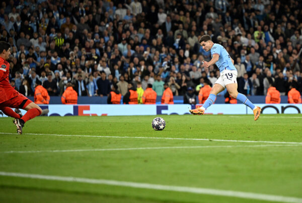 TOPSHOT - Manchester City's Argentinian striker Julian Alvarez (R) scores the team's fourth goal past Real Madrid's Belgian goalkeeper Thibaut Courtois during the UEFA Champions League second leg semi-final football match between Manchester City and Real Madrid at the Etihad Stadium in Manchester, north west England, on May 17, 2023. (Photo by Oli SCARFF / AFP) 
