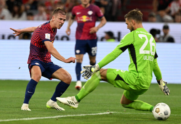 Leipzig's Spanish forward #07 Dani Olmo (L) scores past Bayern Munich's German goalkeeper #26 Sven Ulreich during the German Super Cup football match Bayern Munich v RB Leipzig in Munich, on August 12, 2023. (Photo by CHRISTOF STACHE / AFP) / DFB REGULATIONS PROHIBIT ANY USE OF PHOTOGRAPHS AS IMAGE SEQUENCES AND QUASI-VIDEO. 
