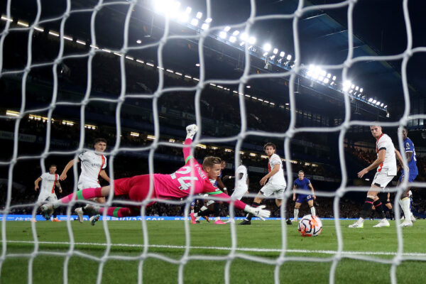 LONDON, ENGLAND - AUGUST 25: (EDITORS NOTE: In this photo taken from a remote camera from behind the goal.) A general view as Thomas Kaminski of Luton Town fails to save a shot from Raheem Sterling of Chelsea who scores their team's first goal during the Premier League match between Chelsea FC and Luton Town at Stamford Bridge on August 25, 2023 in London, England. 