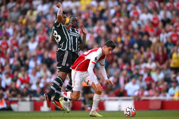 LONDON, ENGLAND - SEPTEMBER 03: Kai Havertz of Arsenal is challenged by Casemiro and Aaron Wan-Bissaka of Manchester United leading to a penalty being awarded which is later overturned following a VAR check during the Premier League match between Arsenal FC and Manchester United at Emirates Stadium on September 03, 2023 in London, England. 