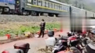 云南男站铁轨上打电话 逼停火车（视频）
