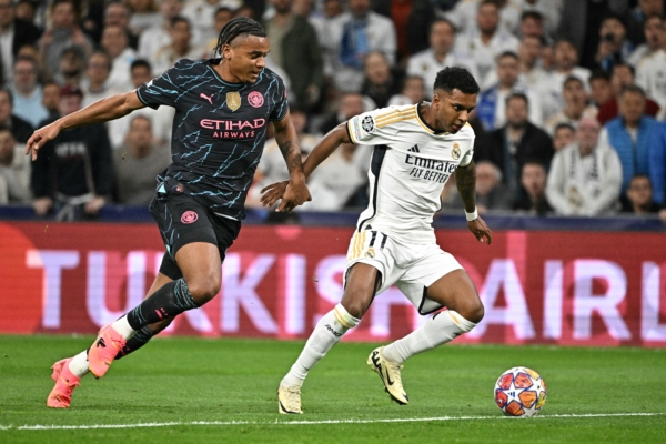 Real Madrid's Brazilian forward #11 Rodrygo (R) fights for the ball with Manchester City's Swiss defender #25 Manuel Akanji during the UEFA Champions League quarter final first leg football match between Real Madrid CF and Manchester City at the Santiago Bernabeu stadium in Madrid on April 9, 2024. (Photo by JAVIER SORIANO / AFP) (Photo by JAVIER SORIANO/AFP via Getty Images)