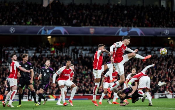 TOPSHOT - Arsenal's German midfielder #29 Kai Havertz (up R) jumps to clear the ball during the UEFA Champions League quarter final first-leg football match between Arsenal and Bayern Munich at the Arsenal Stadium, in north London, on April 9, 2024. (Photo by Adrian DENNIS / AFP) (Photo by ADRIAN DENNIS/AFP via Getty Images)