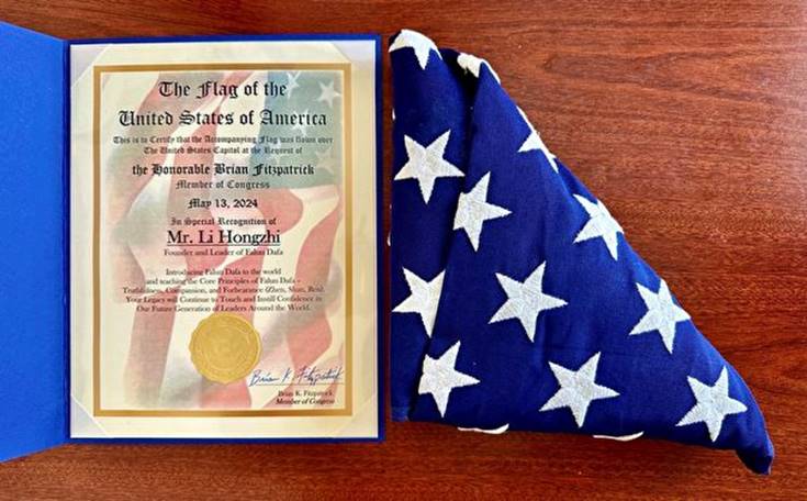 賓州的美國國會議員布萊恩‧菲茨帕特里克（Brian Fitzpatrick）將一面慶祝「世界法輪大法日」和向法輪功創始人李洪志先生致敬的國旗和褒獎證書贈送給法輪功學員珍妮‧希克斯（Jennie Sheeks）。（Jennie Sheeks提供）