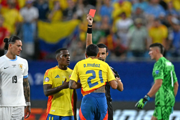 Mexican referee Cesar Ramos shows a red card to Colombia's defender #21 Daniel Munoz during the Conmebol 2024 Copa America tournament semi-final football match between Uruguay and Colombia at Bank of America Stadium, in Charlotte, North Caroline on July 10, 2024. (Photo by Chandan Khanna / AFP) 