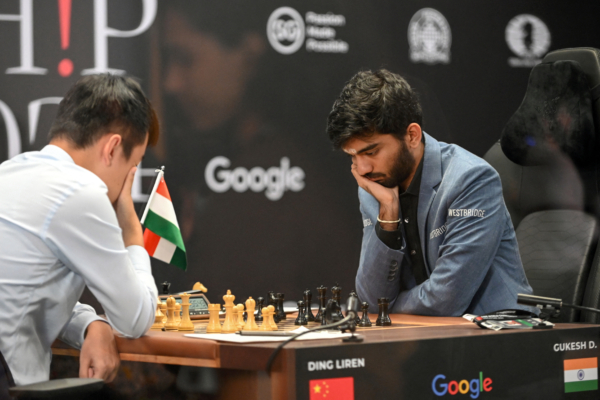 China's chess grandmaster Ding Liren (L) and India's grandmaster Gukesh Dommaraju (R) compete in game 14 of the 2024 FIDE World Championship in Singapore on December 12, 2024. World chess champion Ding Liren, 32, from China, is defending his crown against 18-year-old Indian prodigy Gukesh Dommaraju, who is seeking to make history by becoming the youngest ever undisputed titleholder in the sport. (Photo by SIMON LIM/AFP via Getty Images)