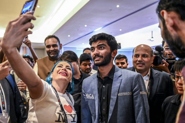 A fan takes a selfie with India's grandmaster Gukesh Dommaraju (C) after his win against China's chess grandmaster Ding Liren in game 14 of the 2024 FIDE World Championship in Singapore on December 12, 2024. The 18-year-old became 