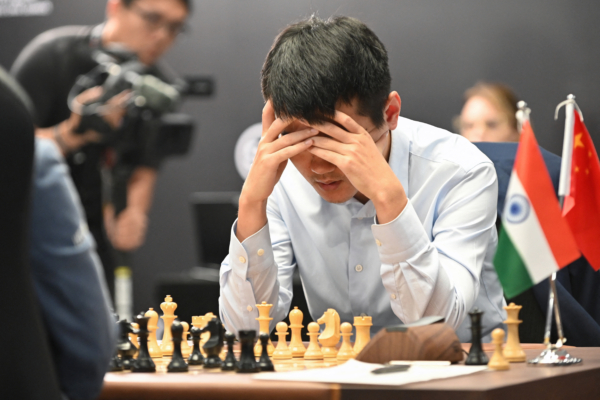 China's chess grandmaster Ding Liren competes against India's grandmaster Gukesh Dommaraju during game 14 of the 2024 FIDE World Championship in Singapore on December 12, 2024. World chess champion Ding Liren, 32, from China, is defending his crown against 18-year-old Indian prodigy Gukesh Dommaraju, who is seeking to make history by becoming the youngest ever undisputed titleholder in the sport. (Photo by Simon Lim / AFP) 