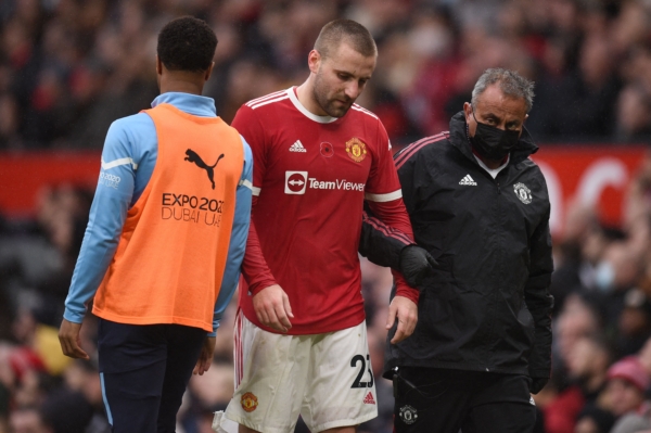 Manchester United's English defender Luke Shaw (C) walks off with an injury during the English Premier League football match between Manchester United and Manchester City at Old Trafford in Manchester, north west England, on November 6, 2021. - RESTRICTED TO EDITORIAL USE. No use with unauthorized audio, video, data, fixture lists, club/league logos or 'live' services. Online in-match use limited to 120 images. An additional 40 images may be used in extra time. No video emulation. Social media in-match use limited to 120 images. An additional 40 images may be used in extra time. No use in betting publications, games or single club/league/player publications. (Photo by Oli SCARFF / AFP) / RESTRICTED TO EDITORIAL USE. No use with unauthorized audio, video, data, fixture lists, club/league logos or 'live' services. Online in-match use limited to 120 images. An additional 40 images may be used in extra time. No video emulation. Social media in-match use limited to 120 images. An additional 40 images may be used in extra time. No use in betting publications, games or single club/league/player publications. / RESTRICTED TO EDITORIAL USE. No use with unauthorized audio, video, data, fixture lists, club/league logos or 'live' services. Online in-match use limited to 120 images. An additional 40 images may be used in extra time. No video emulation. Social media in-match use limited to 120 images. An additional 40 images may be used in extra time. No use in betting publications, games or single club/league/player publications. 