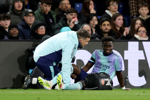 LONDON, ENGLAND - DECEMBER 21: Bukayo Saka of Arsenal receives medical treatment after picking up an injury during the Premier League match between Crystal Palace FC and Arsenal FC at Selhurst Park on December 21, 2024 in London, England. 