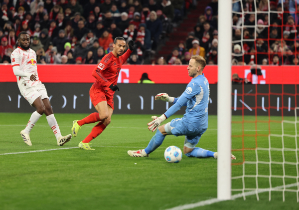 Bayern Munich's German forward #10 Leroy Sane (C) scores the 4-1 past Leipzig's Hungarian goalkeeper #01 Peter Gulacsi (R) during the German first division Bundesliga football match between FC Bayern Munich and RB Leipzig in Munich, southern Germany, on December 20, 2024. (Photo by Alexandra BEIER / AFP) / DFL REGULATIONS PROHIBIT ANY USE OF PHOTOGRAPHS AS IMAGE SEQUENCES AND/OR QUASI-VIDEO 