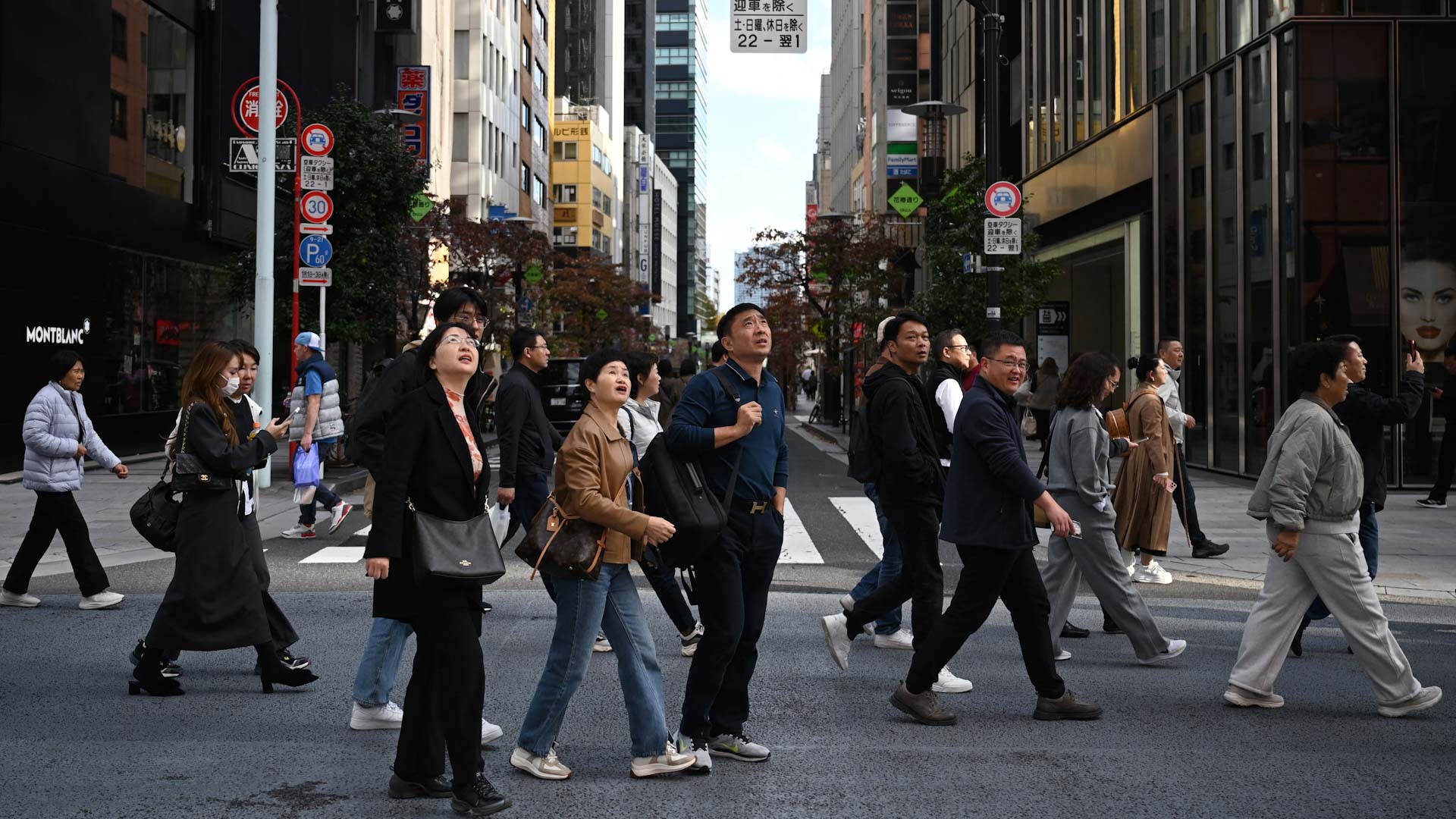 2025年11月16日,一個中國旅行團在東京銀座購物區漫步。隨著中日關係日趨緊張,中共建議其公民避免前往日本旅行。(GREG BAKER/AFP via Getty Images)