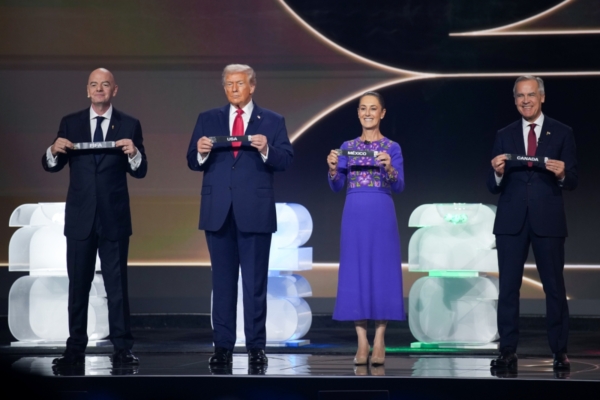 Title: President Trump Attends World Cup Draw At Kennedy Center Created: Friday, December 5th 2025 12:54:09 PM Caption: WASHINGTON, DC - DECEMBER 05: (L-R) FIFA President Gianni Infantino, U.S. President Donald Trump, Mexican President Claudia Sheinbaum, and Canadian Prime Minister Mark Carney participate in the FIFA World Cup 2026 Official Draw with at the John F. Kennedy Center for the Performing Arts December 05, 2025 in Washington, DC. The 2026 FIFA World Cup will take place between June 11 and July 19 featuring 48 teams with matches being played in the United States, Mexico and Canada, the first time the international sporting event will be hosted by three nations.