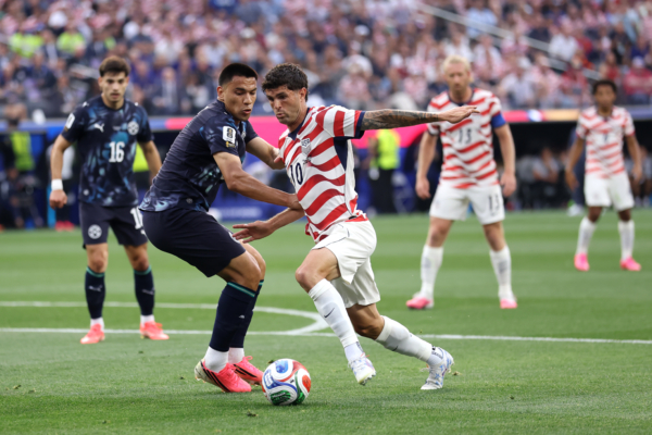 LOS ANGELES, CALIFORNIA - JUNE 12: Christian Pulisic #10 of the United States is challenged by Diego Gomez #8 of Paraguay during the FIFA World Cup 2026 Group D match between USA and Paraguay at Los Angeles Stadium on June 12, 2026 in Los Angeles, California.