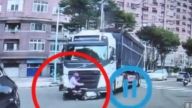 女騎士突切砂石車前方遭拖行 她急抓住車頭求生(視頻)