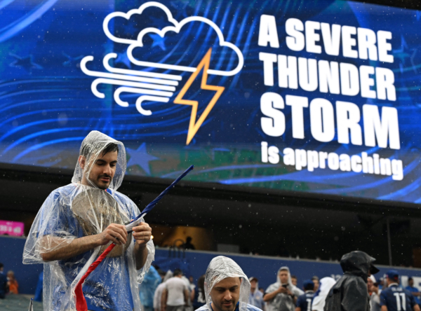 A French fan gestures past a screen showing a severe thunder storm warning during the 2026 World Cup Group I football match between France and Iraq at the Philadelphia Stadium in Philadelphia on June 22, 2026.