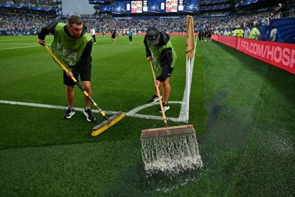 Staff workers drain the water from the field as the 2026 World Cup Group I football match between France and Iraq is suspended due to adverse weather at the Philadelphia Stadium in Philadelphia on June 22, 2026.