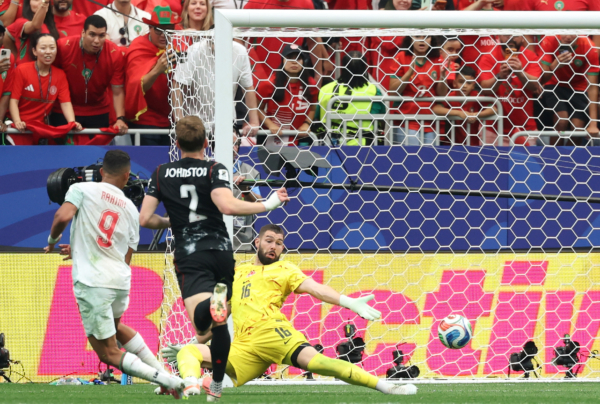 TOPSHOT - Morocco's forward #09 Soufiane Rahimi scores his team's third goal past Canada's goalkeeper #16 Maxime Crepeau during the 2026 World Cup round of 16 football match between Canada and Morocco at the Houston Stadium in Houston on July 4, 2026.