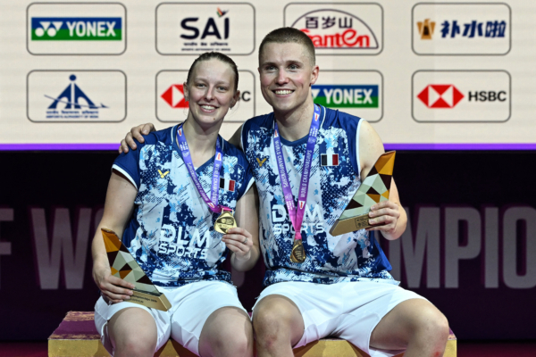 France's Thom Gicquel (R) and Delphine Delrue celebrate on the podium during an awards ceremony after winning against China's Feng Yan Zhe and Huang Dong Ping in their BWF World Championships mixed doubles final badminton match at the Indira Gandhi Indoor Stadium in New Delhi on August 23, 2026.