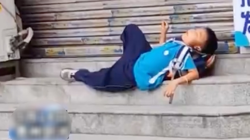 妈妈忘接孩子放学 男孩淡定躺台阶吃烤串（视频）